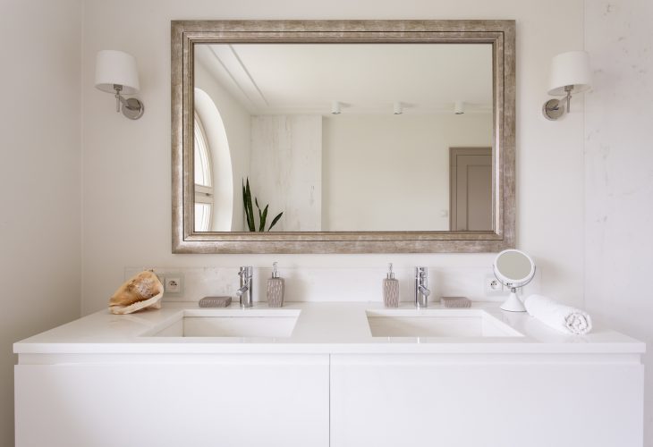 Cropped shot of a white vanity top with two sinks and a stylish mirror in bathroom interior